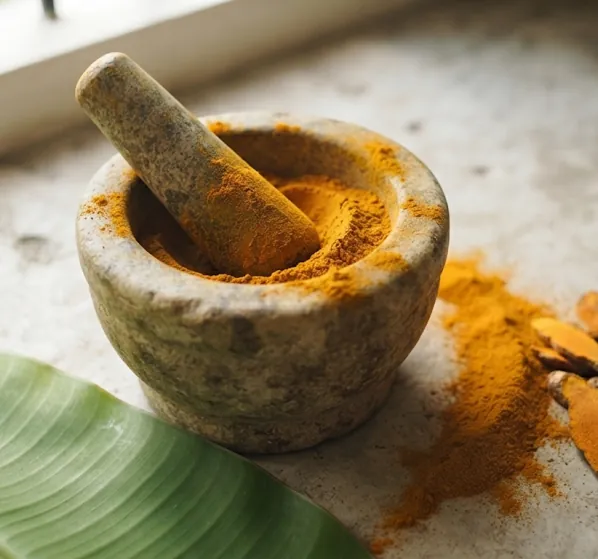 Turmeric powder freshly ground in a stone mortar